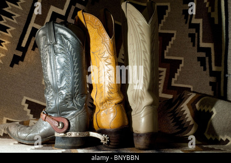 Leather cowboy boots, (gray pair, with silver spurs, made of ostrich skin) on Navajo Two Gray Hills Indian blanket. PR Stock Photo
