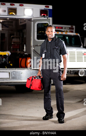 African American paramedic standing by ambulance Stock Photo