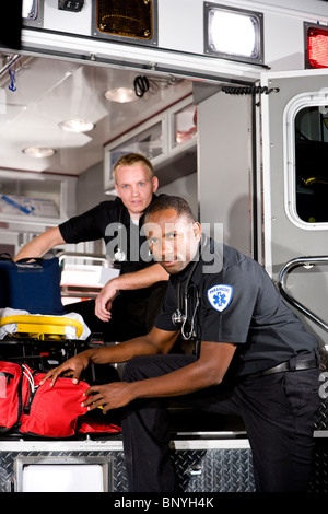 Multiracial paramedics preparing medical equipment in ambulance Stock Photo