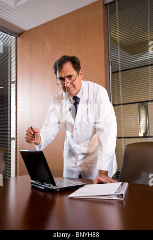 Doctor or scientist in office using laptop computer Stock Photo