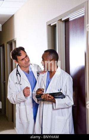 Multi-ethnic doctors discussing chart in hallway Stock Photo