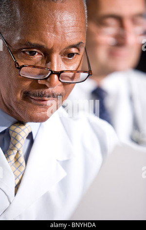 Close up of African-American doctor reading paperwork Stock Photo