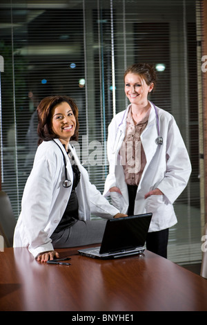 Two female doctors with laptop in boardroom Stock Photo