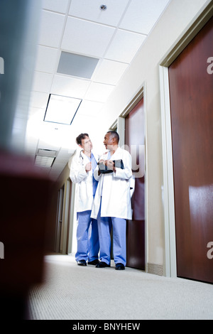 Mature doctors conversing in office corridor Stock Photo