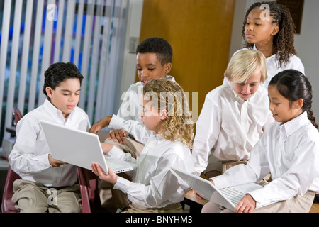 Group of elementary school students in class using laptops Stock Photo