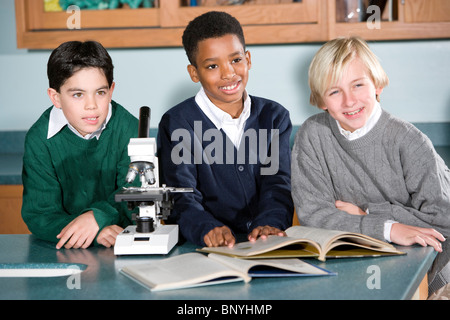 Multi-ethnic elementary school children in science lab using microscope Stock Photo