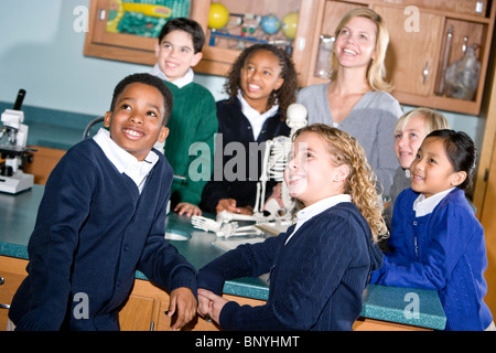 Elementary school students and teacher in science lab looking up Stock Photo