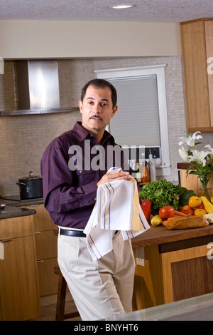 Middle-aged Hispanic man standing at home in kitchen Stock Photo