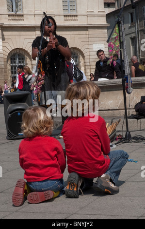 Arles, France, Young Children From Behind, Watching Local Musicians Playing on the Street in Town, Bullfighting Festival, music festival sitting down, festivals with family Stock Photo