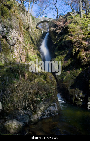 Old packhorse bridge over Aira Force Waterfall near Ullswater Lake District Cumbria UK Stock Photo