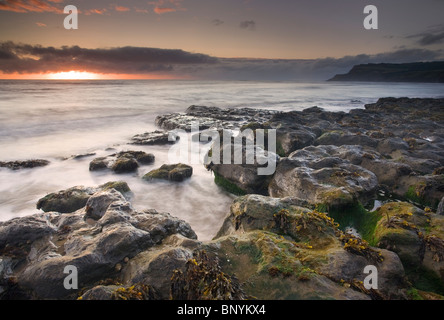 colourful sunrise over The North Sea seen from Boggle Hole, Ravenscar, The North York Moors, North Yorkshire, UK Stock Photo