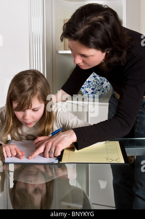 Young teenager girl doing her homework with her mother's help Stock Photo