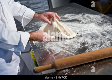 Professional baker rolling dough with pin Stock Photo