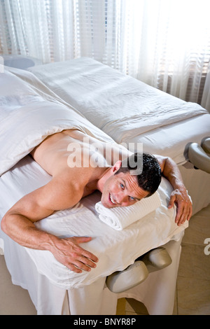 Handsome man in health spa lying on massage table Stock Photo