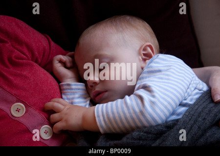 Baby boy (16 months old) sleeping on his mothers chest. Stock Photo
