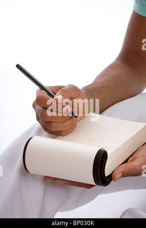 Male writing in notebook Stock Photo