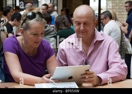 Couple using iPad - Apple Store - Covent Garden - London Stock Photo
