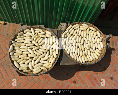 Small bananas curing under the sun on the street of Luang Prabang, Northern Laos Stock Photo