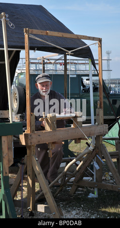 old man working on an old fashioned lathe turning wood at the kemble steam rally as one of the exhibits 2010. Stock Photo