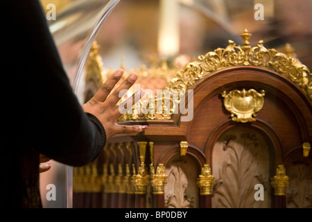 A Worshipers places her hand on the relics of Saint Therese of Lisieux  at St John's Catholic Cathedral in Portsmouth. Stock Photo