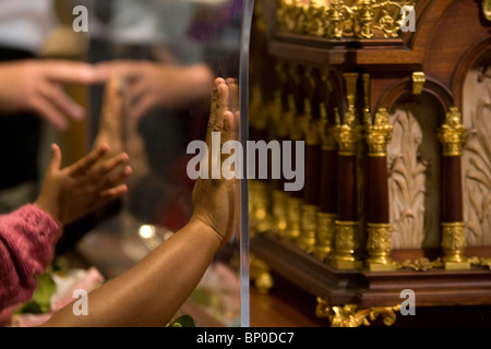 Worshipers places there hands on the relics of Saint Therese of Lisieux  at St John's Catholic Cathedral in Portsmouth. Stock Photo