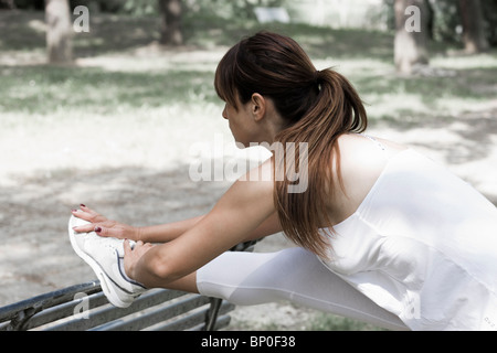 Woman stretching on a bench Stock Photo