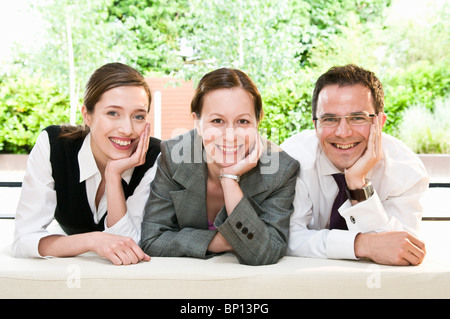 3 happy colleagues smile at camera Stock Photo