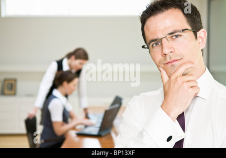 Thoughtful business man looks to camera Stock Photo