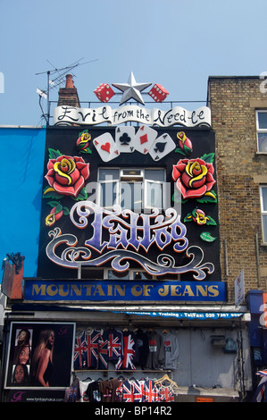 Shop front on Camden High Street Evil From The Needle, Mountain of Jeans and hairdresser North London England UK Stock Photo