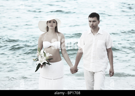 Romantic couple near the ocean with flowers Stock Photo