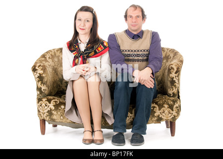 bored old looking couple sitting on vintage couch isolated on white Stock Photo