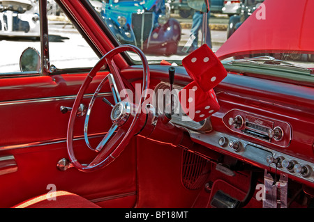 This editorial stock image is a 1950's era, retro car interior of a restored classic Chevrolet with a cherry red interior. Stock Photo