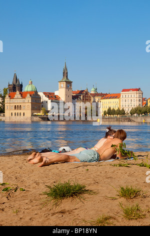 prague - people enjoying summer strelecky island beach - old town in background Stock Photo