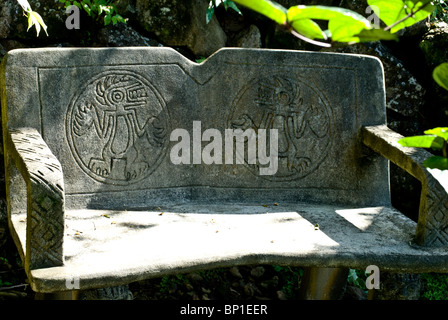 A sun dappled stone bench sitting in the shade, Bocas del Toro, Panama Stock Photo