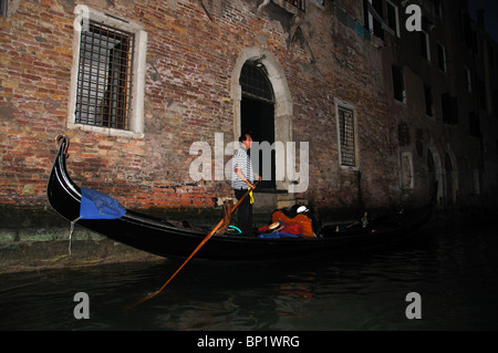 Gondola ride after dark in the small canals of Venice Italy Stock Photo