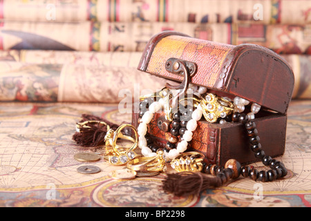 Antique chest with jewelry on vintage map Stock Photo