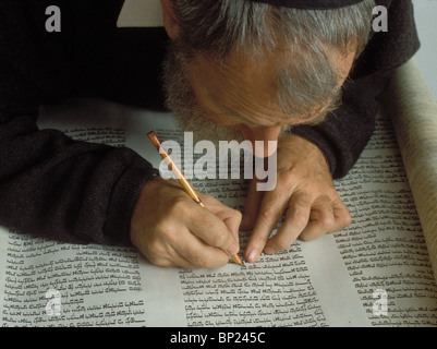 TORAH SCROLL IS BEING WRITTEN BY HAND ON PARCHMENT BY A PROFFESIONAL SCRIBE USING TRADITIONAL WRITING TOOLS REED PENS & FETHERS Stock Photo