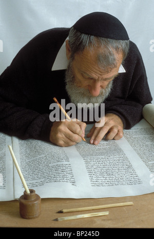 TORAH SCROLL IS BEING WRITTEN BY HAND ON PARCHMENT BY A PROFFESIONAL SCRIBE USING TRADITIONAL WRITING TOOLS REED PENS & FETHERS Stock Photo