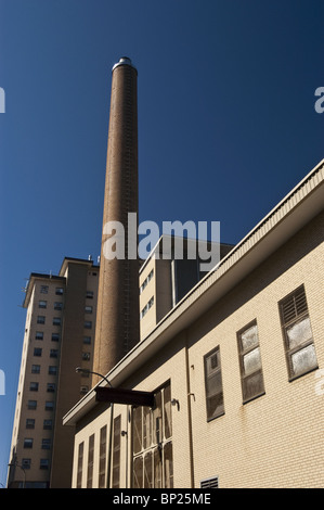 Old factory chimney at 1060 St Elisabeth Street, Montreal, Quebec, Canada. Industrial architecture under a clear blue sky. Stock Photo