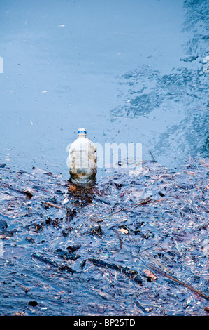 a plastic bottle abandoned into water, pollution concept