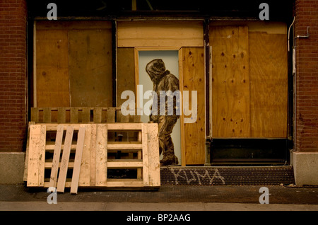 Graffiti art showing a man in a hoody painted in a wooden doorway, in the Soho district of New York City, USA. Stock Photo