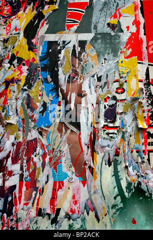 Torn flyposters showing a black woman's face, Camden, London Stock Photo