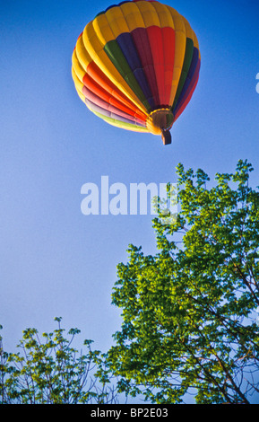 Hot air balloon riders soar , float over Lancaster farm fields, early morning. copy space Stock Photo