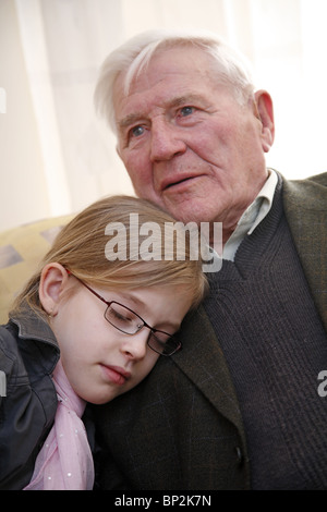 Granddaughter cuddling up to her grandfather Stock Photo