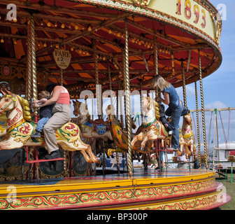 mothers and children getting ready to have a ride on the carousel at the fair at the steam rally kemble 2010 Stock Photo