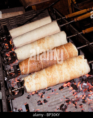 HUNGARIAN KURTOS KALACS COOKING ON WOODEN SPIT Stock Photo