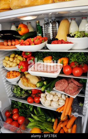 VIEW INSIDE REFRIGERATOR WITH SHELVES FILLED WITH FRESH FOOD Stock Photo