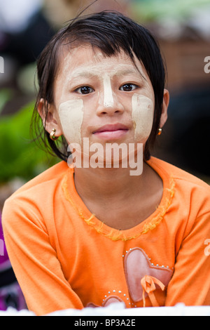 a young Burmese girl wearing tanaka in a central market Stock Photo