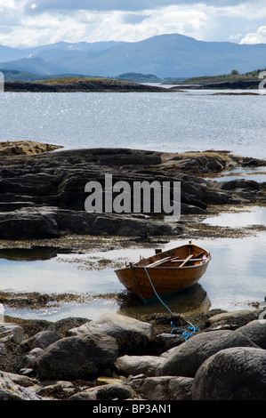 Traditional wooden rowing boat beached on a rocky Island in Norway Stock Photo