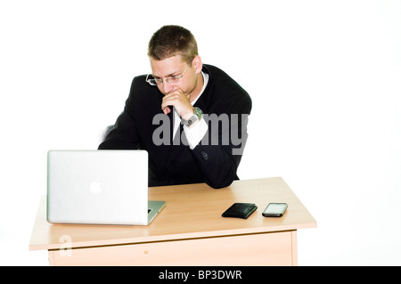 Young businessman working on a desk with Apple laptop - Macbook Pro 13,iPhone 3G and wallet - isolated on white background Stock Photo
